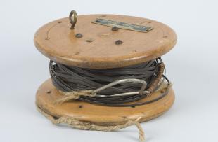 steel surveyor's tape on wooden spool