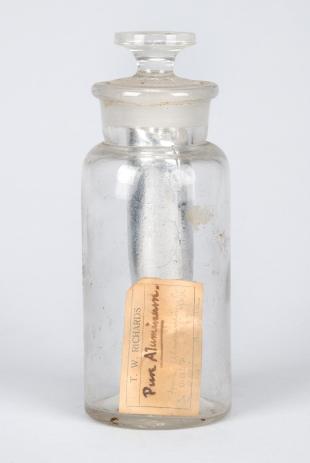 stoppered glass bottle containing rod of aluminum