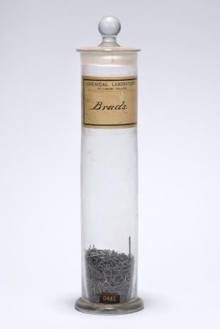 cylindrical bottle filled with iron brads