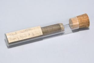 spool of metal wire in a stoppered glass test tube